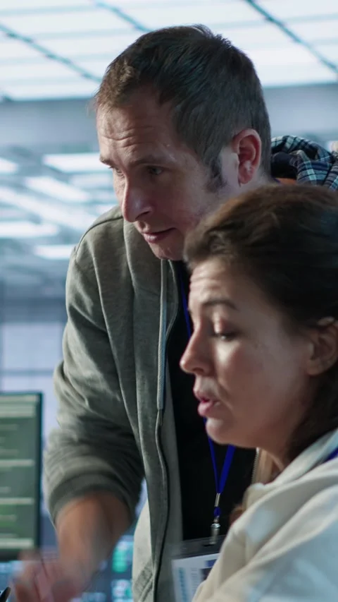 Woman requesting help from senior engineer to fix error in high tech data center Stock Footage 319574353