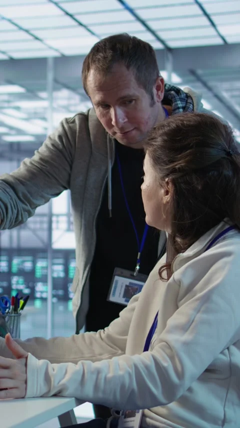 Woman requesting help from senior engineer to fix error in high tech data center Stock Footage 319576531