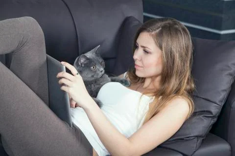 Woman resting on a sofa with tablet computer Stock Photos