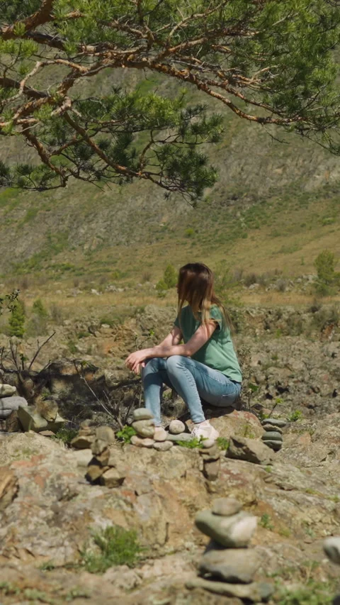 Woman rests in pine tree shadow among stone pyramids Stock Footage 309881184