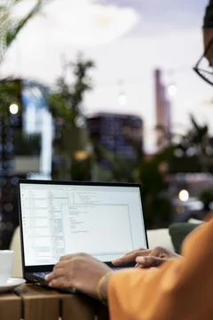 Woman reviews program code in coding language on laptop in close-up Stock Photos