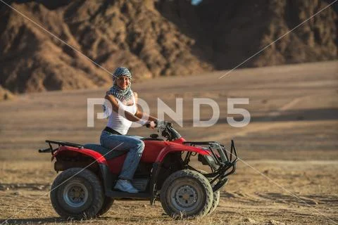 The woman ride a quad bike in the desert Stock Photos