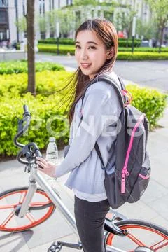 Woman riding a bicycle on city background Stock Photos