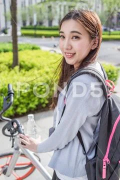 Woman riding a bicycle on city background Stock Photos