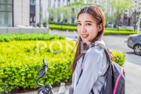 Woman riding a bicycle on city background Stock Photos