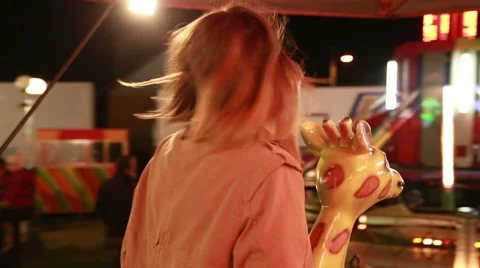 Woman riding carousel in amusement park, waving to the camera Stock Footage 59556204
