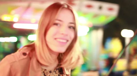 Woman riding on roundabout and beckoning to camera in amusement park Stock Footage 59556322