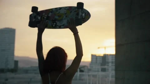 Woman rising his skate board in Barcelona during sunset in slow motion Stock Footage