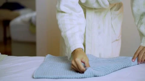 Woman with robe doing routine chore and wrapping towels Stock Footage 146376614