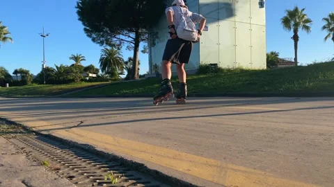 Woman rollerblading in low angle view along a paved waterfront path Stock Footage 345361739