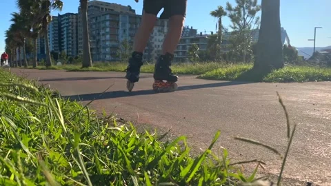 Woman rollerblading in low angle view along a paved park Stock Footage 345361789