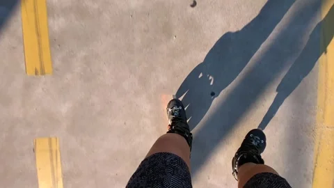 Woman rollerblading in top-down view along a marked paved lane Stock Footage 345361756