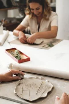 Woman rolling clay, making ceramic plate in studio workshop Foto stock