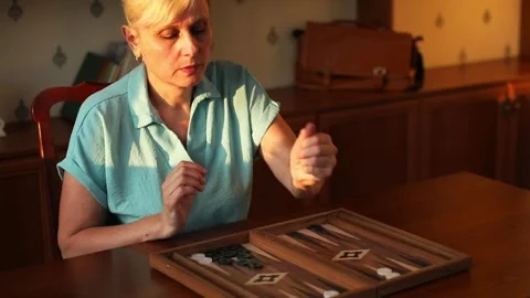 Woman Rolling Dice While Playing Backgammon at Home Stock Footage 332639923