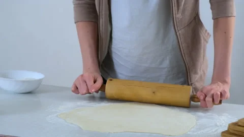Woman is rolling dough for dumpings using rolling pin on table, hands closeup. Stock Footage 158437112