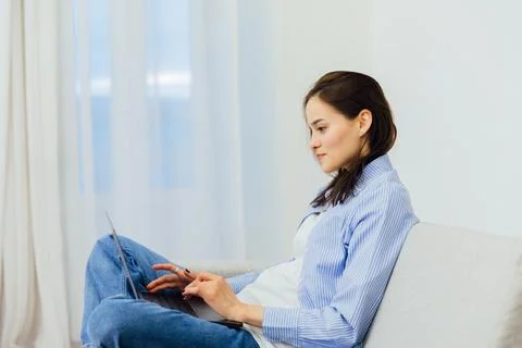 Woman in a room on the couch with computer programmer work online Foto stock