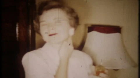 Woman rubs perfume on her neck 1950s vintage film home movie 2188 Stock Footage