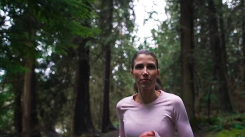 Woman runner jogging on forest path stops to enjoy nature. Stock Footage 95642685