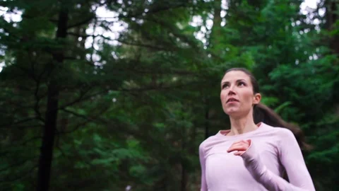 Woman runner jogging on forest path stops to enjoy nature. Stock Footage 95642701