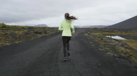 Woman runner running on dirt road trail attaching hair using hairband elastics Stock Footage