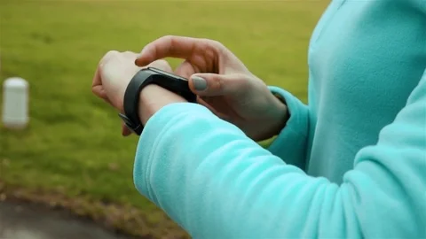 Woman runner using smart watch fitness tracker in park Stock Footage