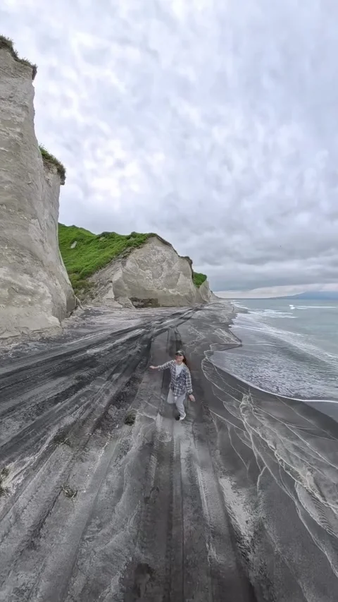 Woman Running Along Dramatic Black Sand Beach Video stock 340872293