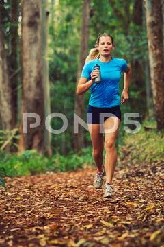 Woman running in the forest Stock Photos