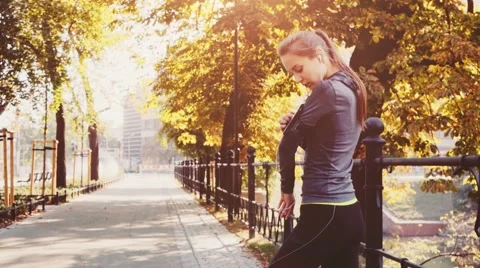 Woman Running in park, using Smartphone. STABILIZED shot, SLOW MOTION 120 fps. 動画素材 66754988