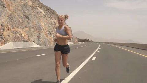 Woman running in slow motion on an empty road Stock Footage 90636282