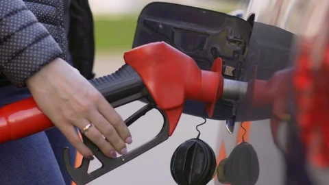 A woman runs a gasoline car at a gas station. Close-up. Stock Footage