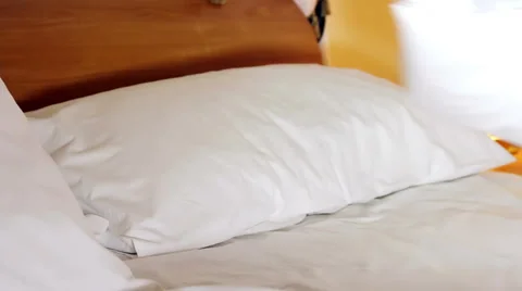 Woman runs the linen on the bed Stock Footage