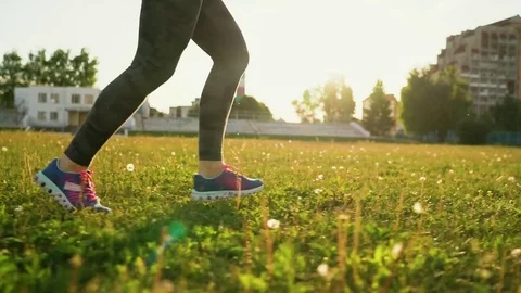 Woman runs through the stadium at sunset Stock Footage