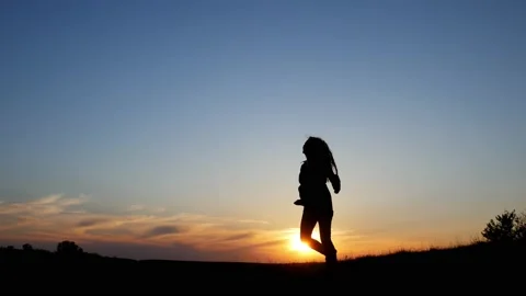 Woman 's silhouette happy at sunset. Carefree, freedom and joy concept Stock Footage