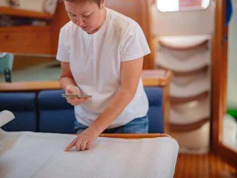 Woman Sailor Studying Navigation Map Inside Yacht Cabin Interior Stock Photos