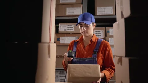 Woman scanning barcode from boxes with labels in modern warehouse 스톡 동영상 250165528