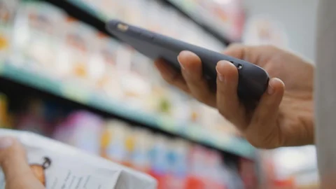 Woman Scanning Product Bar Code in the Shop Using Mobile Phone App. Digital Stock Footage 104268772