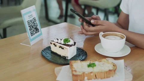 A woman scans a bar code to order more food. A woman scans a QR code to pay for  Video stock 164231020
