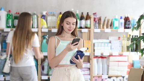 Woman scans QR code on label of spray glass cleaner for windows using her Stock Footage 330040051