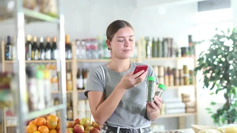 Woman scans the QR code of a package of natural spices on a mobile application Stock Footage 317135902