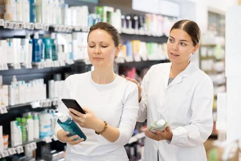 Woman scans QR code on packaging of face cream and listens attentively to Stockfoto's