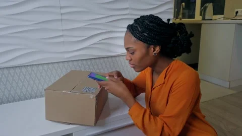 Woman scans the QR code on the parcel she received and it surprises her Stock Footage 172366778
