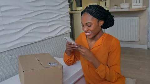 Woman scans the QR code on the parcel she received and smiles  Stock Footage 172366971