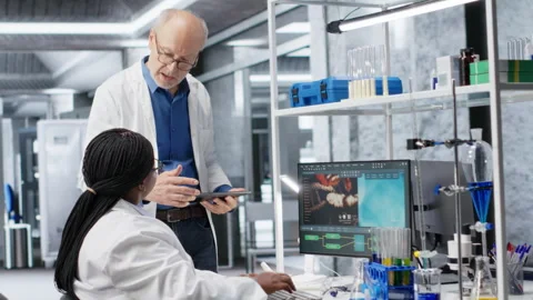 Woman scientist examines experiment data with coworker in a laboratory Stock Footage 318425722