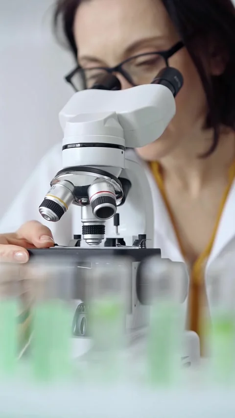 Woman scientist with glasses using microscope in laboratory. Microbiology Stock Footage 281407017