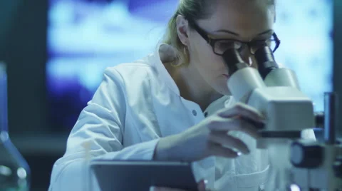 Woman Scientist Using Microscope and Tablet in Laboratory Stock Footage 48594513