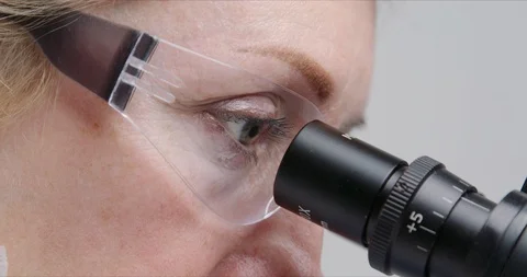 Woman scientist using microscope in a laboratory. Stock Footage 125850198