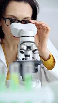 Woman scientist using microscope in laboratory. Microbiology science concept Stock Photos