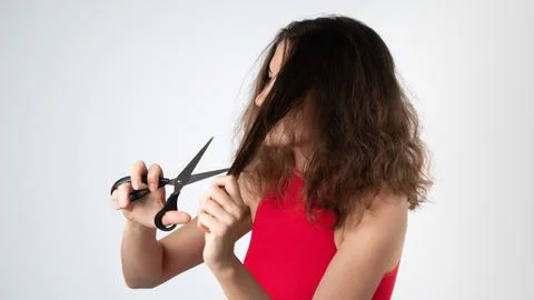 A woman with scissors cuts off the split ends of naughty, unhealthy hair Stock Photos