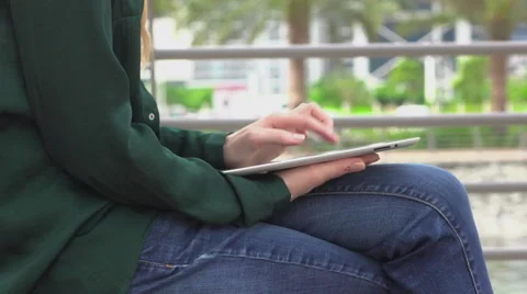 Woman scrolling the tablet on the bench Stock Footage 62895135