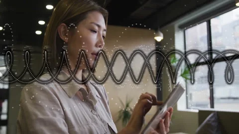 Woman scrolling tablet screen in café, reviewing technology data with looping Stock Footage 312116192